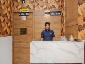 Sahara Dormitory في مومباي: رجل يقف خلف كونتر في غرفة