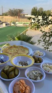 een witte tafel met borden voedsel erop bij مزرعه فلج المعلا in Falaj al Mu‘allá