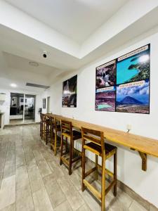 a long bar with wooden chairs and posters on the wall at Hostal Villa Marta in Santa Ana