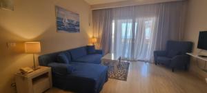 ein Wohnzimmer mit einem blauen Sofa und einem Fenster in der Unterkunft Azzurra Sahl hasheesh in Hurghada