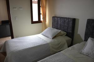 a bedroom with two beds and a window at Confortable apartamento cerca de la plaza principal in Villa de Leyva