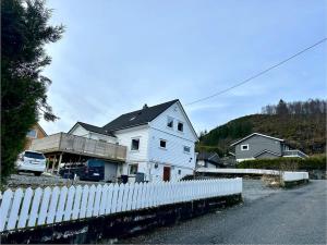 a white house behind a white picket fence at Stort, koselig hus i naturområde in Bergen