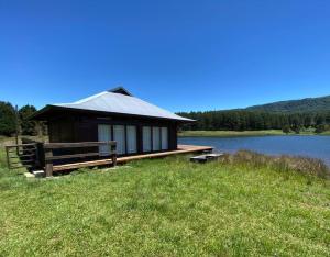 a small cabin on the edge of a lake at eKuthuleni - Wooden Cabin over the dam in Howick