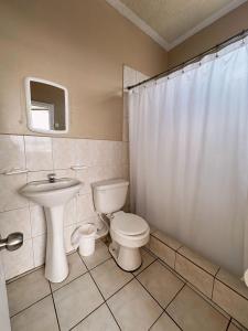 uma casa de banho com um WC e um lavatório em Hostal Posada Del Sol em Guayaquil