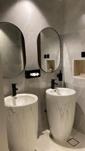 a bathroom with two sinks and a mirror at مزرعه فلج المعلا in Falaj al Mu‘allá