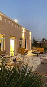 a patio with couches and tables in front of a building at مزرعه فلج المعلا in Falaj al Mu‘allá