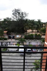 einen Balkon mit Blick auf eine Straße mit Palmen in der Unterkunft Amazing Grace Apartment in Ikeja