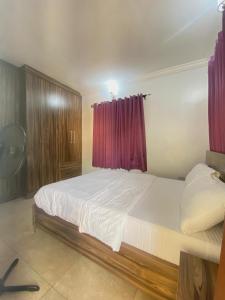 ein Schlafzimmer mit einem großen Bett mit einem roten Vorhang in der Unterkunft Amazing Grace Apartment in Ikeja