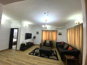 ein Wohnzimmer mit einem Sofa und einem TV in der Unterkunft Amazing Grace Apartment in Ikeja