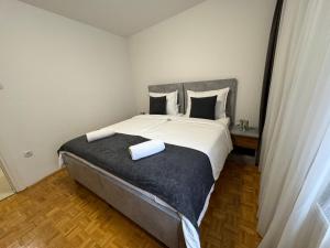 a bedroom with a large bed with two towels on it at Estrada Apartment in Sarajevo