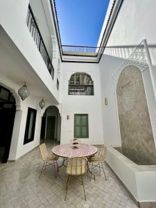 a patio with a table and chairs in a building at Riad Fisaline en exclusivité pour vous à Marrakech in Marrakesh