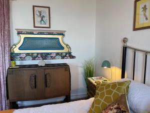 ein Schlafzimmer mit einem Bett und eine Kommode mit einem Spiegel in der Unterkunft "The Quirky" Seafront Apartment in Eastbourne