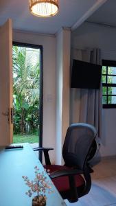 Zimmer mit einem Stuhl, einem Tisch und einem Fenster in der Unterkunft Lofts da Monica in Rio de Janeiro