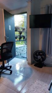 uma sala de estar com uma cadeira e uma televisão em Lofts da Monica no Rio de Janeiro