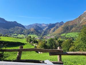 a wooden fence with a view of mountains at Casa Rural El Puente de Agues in Soto De Agues