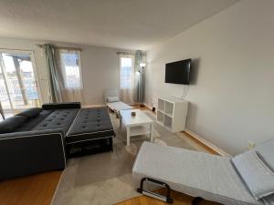 uma sala de estar com um sofá e uma televisão em ArbourRidge Vacation Home - 5 bedrooms sleeps 14 people em Kingston