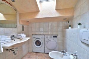 a bathroom with a washing machine and a sink at Bezaubernde Ferienwohnung nahe des Kloster Andechs in Andechs