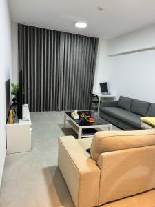 Al jada apartment Sharjah في الشارقة: غرفة معيشة مع أريكة وطاولة