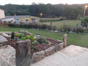 un jardin avec des rochers et des plantes dans une cour dans l'établissement Casa do Maestro - Costa da Morte, à Vimianzo