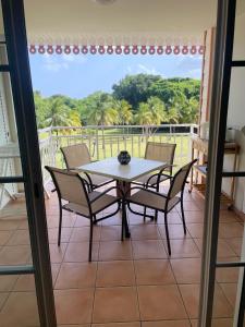 a dining room with a table and chairs on a balcony at Studio Charme et cosy à Sainte-Luce Martinique in Sainte-Luce