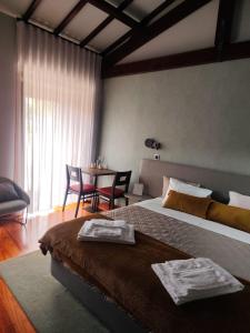 a bedroom with a bed and a table with chairs at Quinta do Esquilo - Hotel Rural in Rendufe