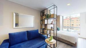 sala de estar con sofá azul y cama en Apartasuites Cabrera 85 en Bogotá
