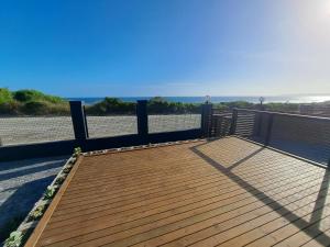 a wooden deck with a view of the ocean at WavesEnd Wilderness Self-catering Units in Wilderness