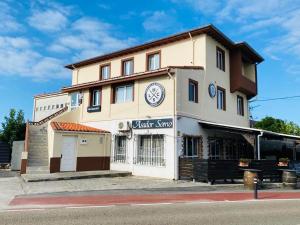 a building with a clock on it on a street at Hostal La Concha Somo in Somo