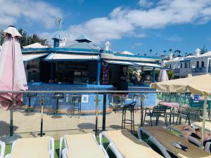 una piscina con tumbonas y un edificio en Bungalow Terrace&Pool near the Beach en Maspalomas