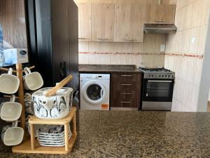a kitchen with a stove and a washing machine at Burj Al saadah Al mamzar sharjah in Sharjah