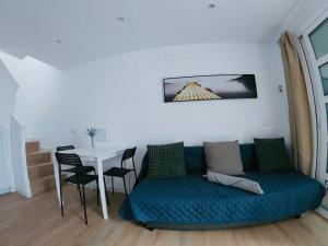 a living room with a blue couch and a table at Bungalow Terrace&Pool near the Beach in Maspalomas