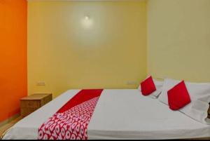 1 dormitorio con 1 cama grande con almohadas rojas en OYO Flagship Hotel Diamond Palace, en Kumbalgod