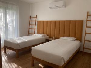 1 Schlafzimmer mit 2 Betten und einem großen Kopfteil in der Unterkunft 45 Pines West in Açafora