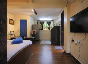 a small room with a bed and a television at Ranger - Bandra West in Mumbai