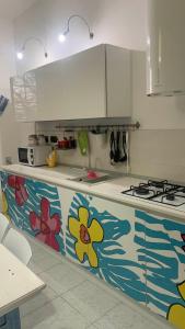 a kitchen with a counter with flowers painted on it at RELAX HOUSE in Giurdignano +23 photos