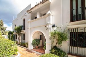 an entrance to a white building with an archway at Villacana Community Family Beach Resort in Estepona