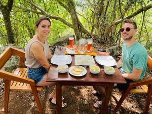 a man and a woman sitting at a picnic table at Rock n Fall Nature Resort in Ella