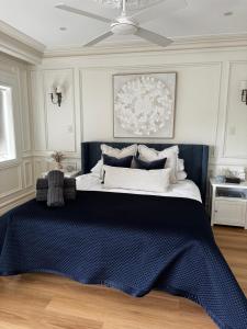 a bedroom with a large bed with a blue blanket at Tusan Villa Little Manly in Sydney