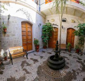 a courtyard with a fountain and a bench in a building at Casa El Errante in Arequipa