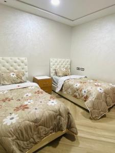 1 dormitorio con 2 camas y vestidor en اقامة باستور, en Oujda