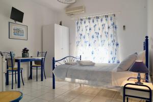 a bedroom with a bed and a table and a window at Leventis Apartments in Rovies
