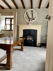 a living room with a table and a fireplace at The Old Granary Seahouses in North Sunderland