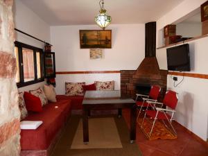 a living room with a couch and a table and a tv at House of dreams in bin el ouidane in Bine el Ouidane