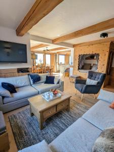 ein Wohnzimmer mit 2 Sofas und einem Tisch in der Unterkunft Chalet Lè Lodzé - Pieds des pistes in La Rosière