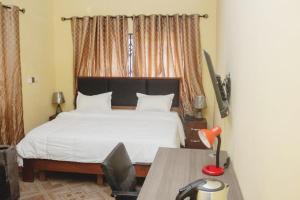 STEPMENS GUEST HOUSE في Botianaw: غرفة نوم مع سرير وطاولة مع مكتب sidx sidx
