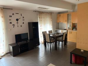 a dining room with a table and a clock on the wall at Smile Stay Apartment in Alexandroupoli