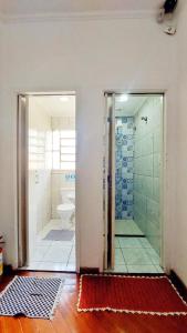 La salle de bains est pourvue d'une douche, de toilettes et d'une porte en verre. dans l'établissement Red Monkey Hostel Barra Funda, à São Paulo