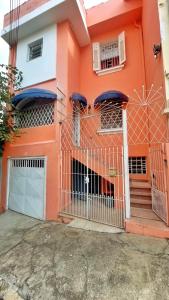 una casa naranja con una puerta delante de ella en Red Monkey Hostel Barra Funda en São Paulo