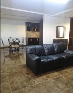 um sofá de couro preto numa sala de estar com uma mesa em Paloma em Ensenada