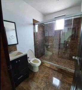 uma casa de banho com um chuveiro, um WC e um lavatório. em Paloma em Ensenada